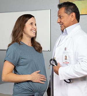 Person talking to doctor in exam room.