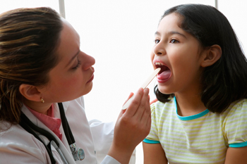 Doctor looking at girl's throat