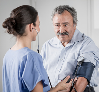 Healthcare provider taking blood pressure of an older man