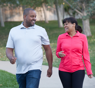 Man and women outdoors, walking for exercise